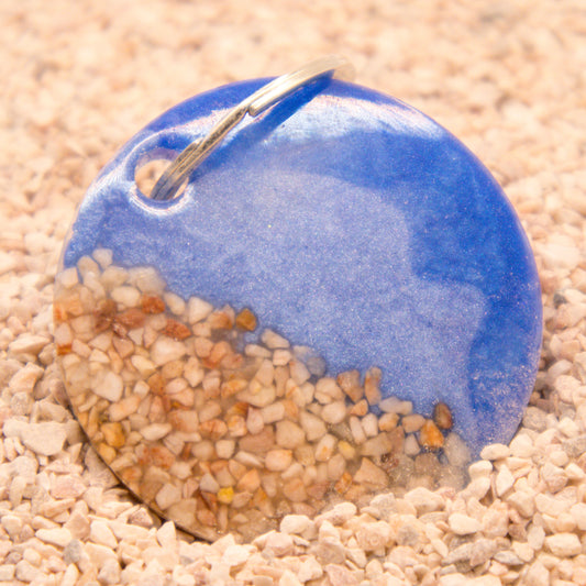 Placa redonda con diseño playero azul y arena. Estilo veraniego ideal para perros.