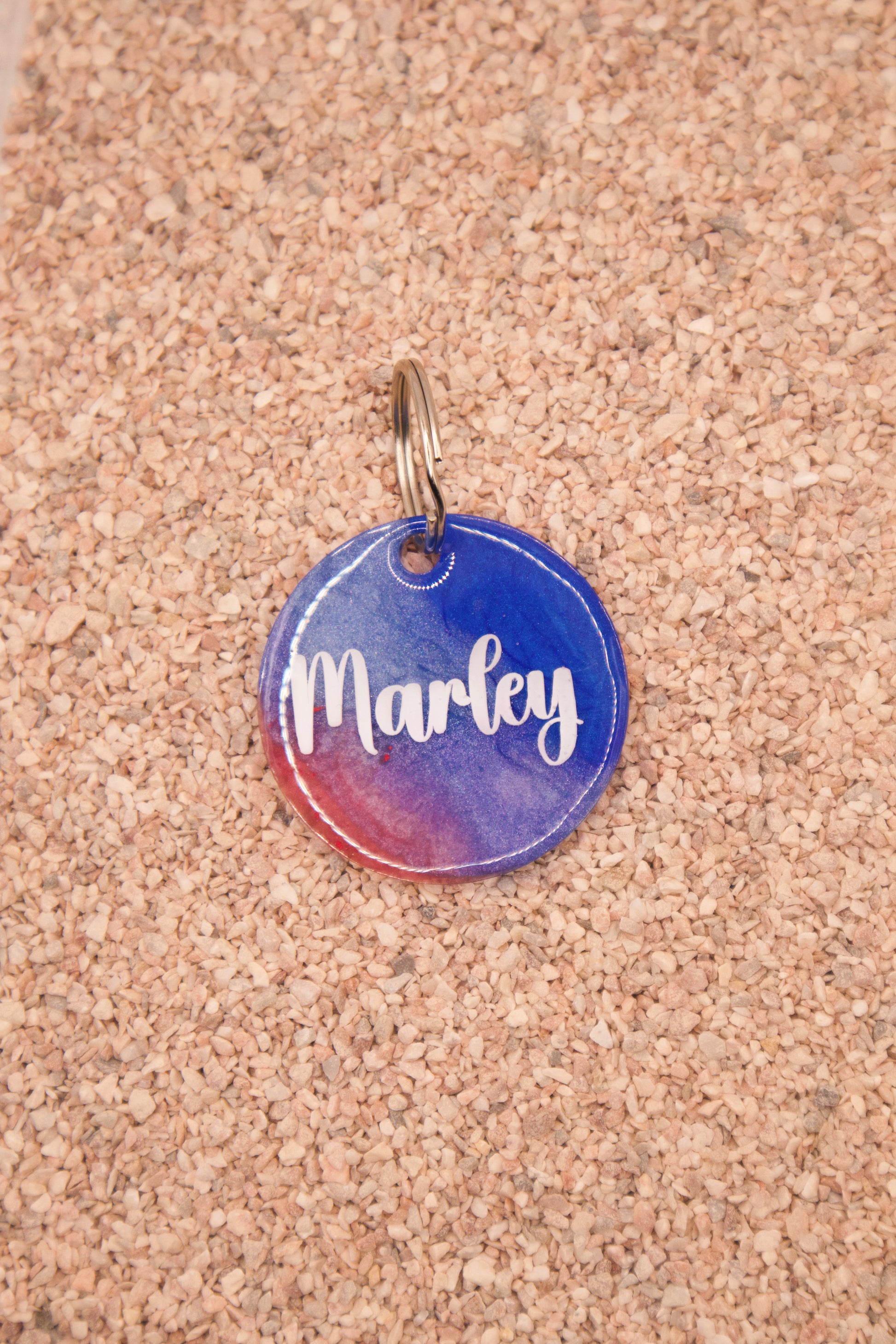Placa redonda personalizada con nombre Marley en tonos azules y rosas. Estilo MunBeach.