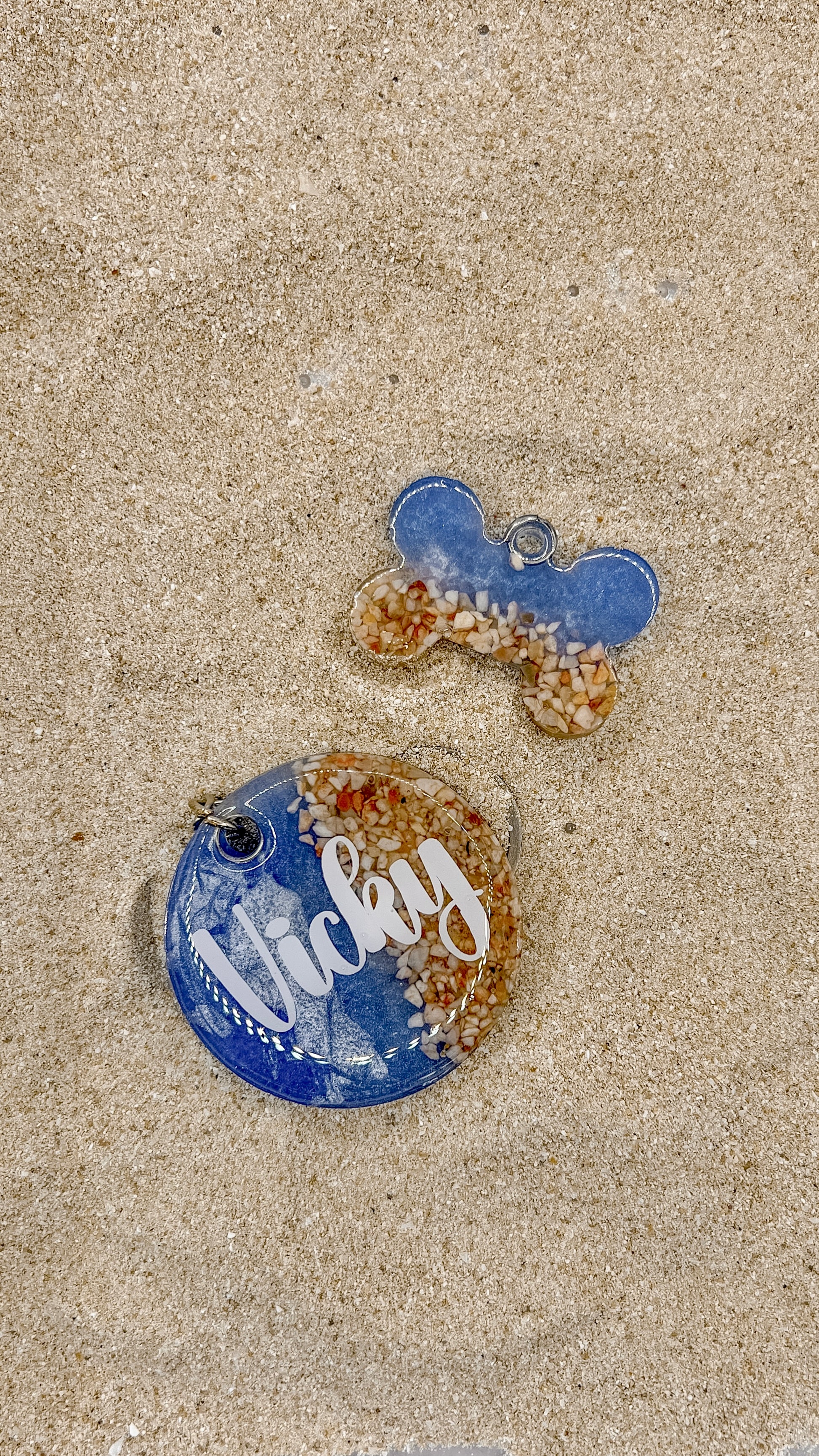 Placa azul y arena en forma de hueso y círculo con nombre Vicky. Estilo playero para mascotas