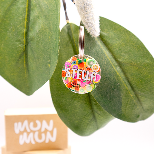 Placa redonda con fondo frutal y nombre Stella. Estilo colorido y alegre.