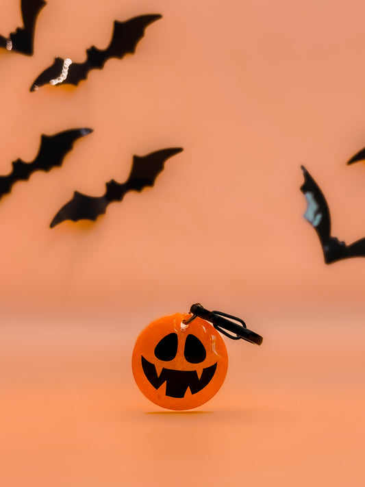 Placa de calabaza Jack-o’-lantern naranja con clip, diseño icónico para Halloween.