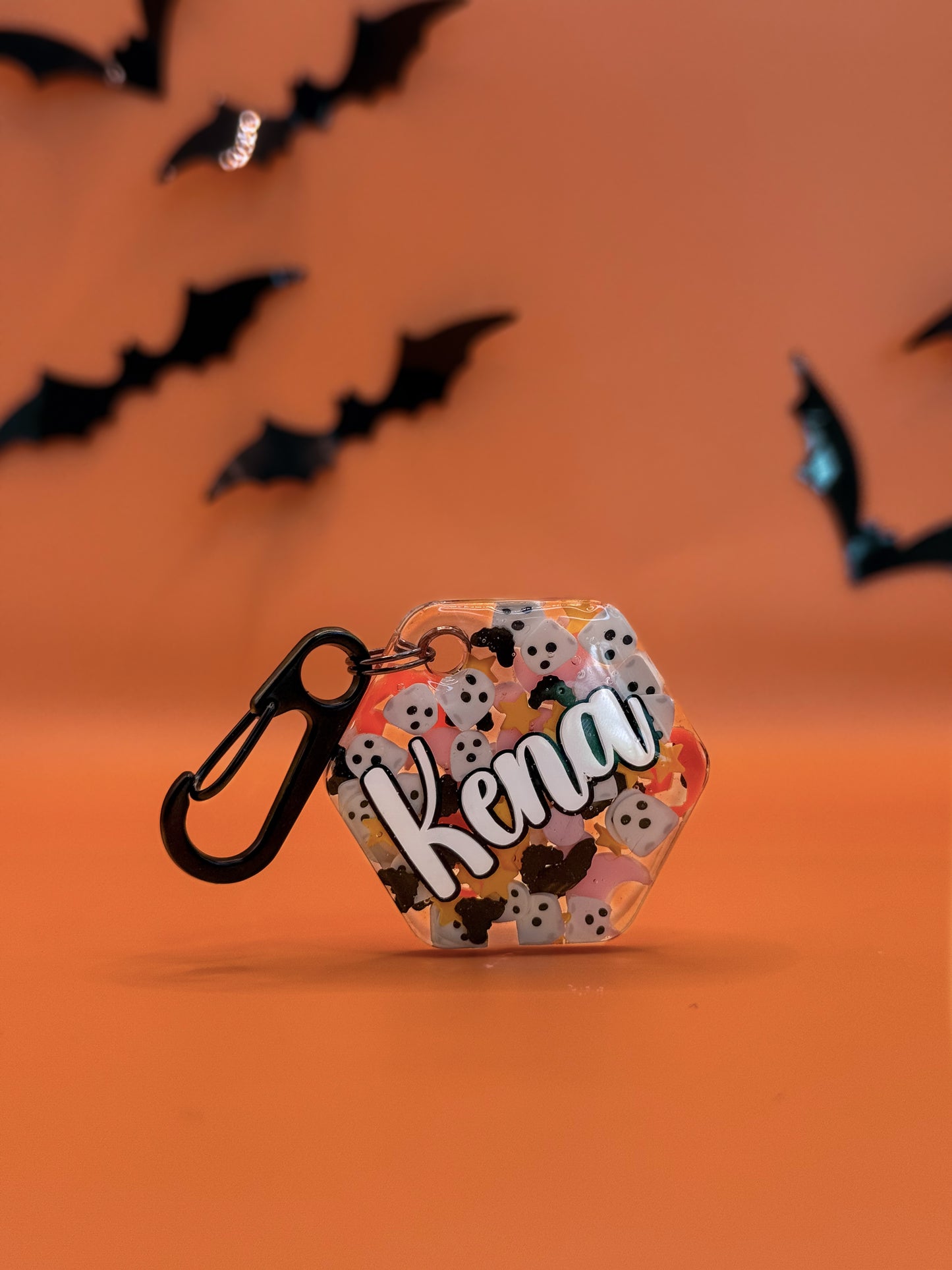 Placa con nombre “Kena” en fondo naranja y negro, diseño otoñal ideal para la temporada.