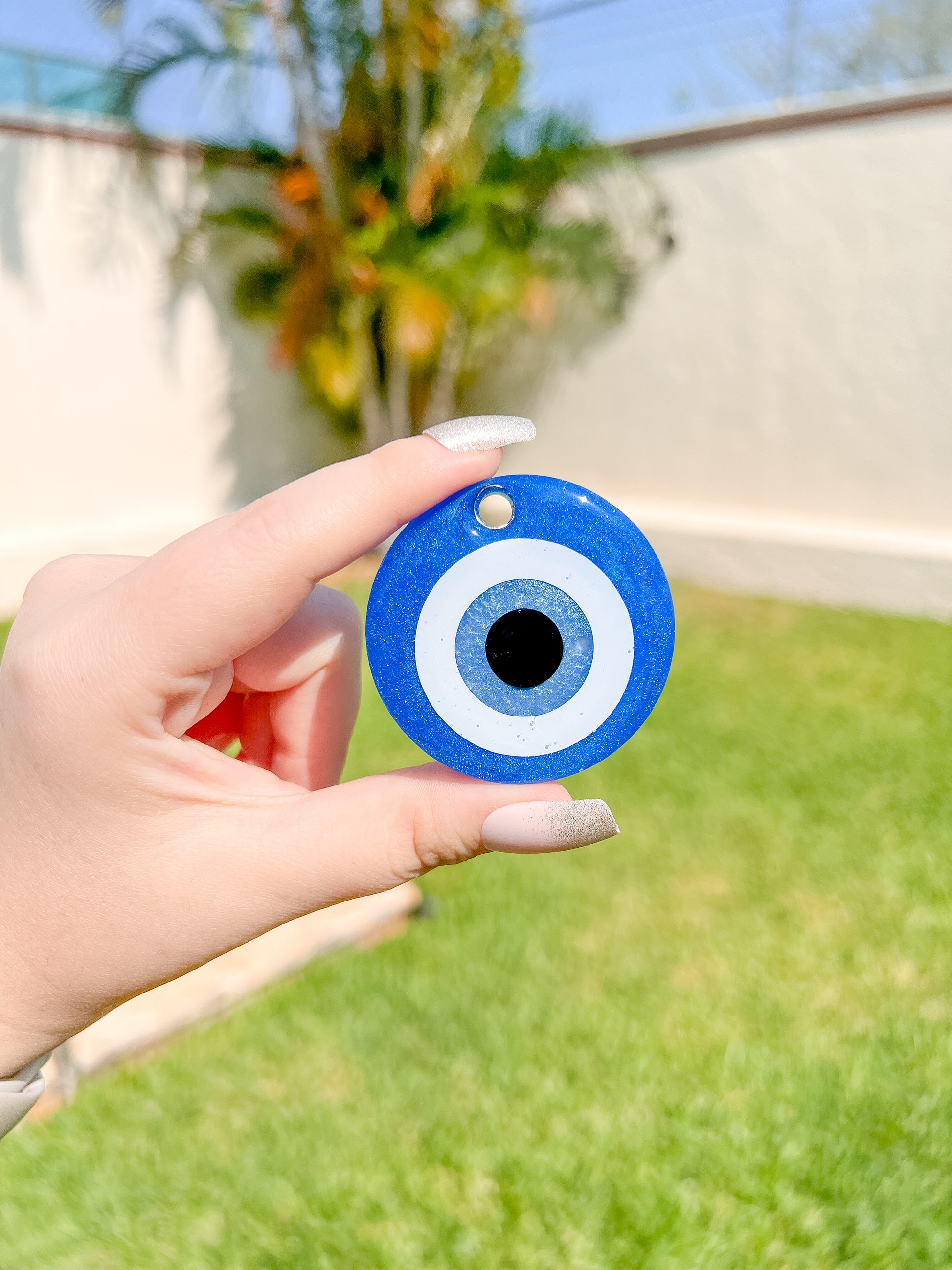Placa de ojo turco azul sostenida con la mano. Diseño contra la mala vibra.