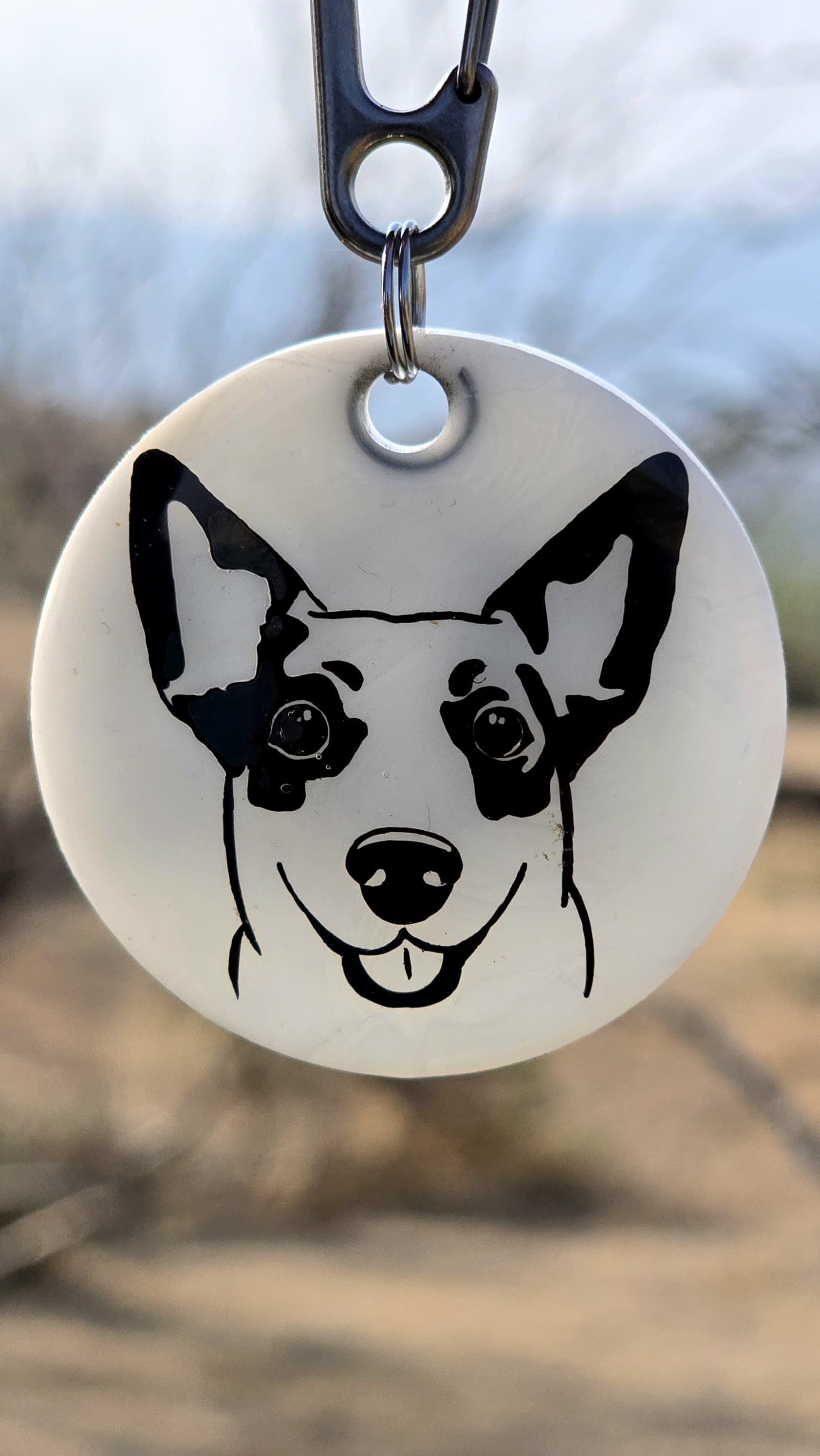 Placa redonda con ilustración de perro sonriente en negro sobre blanco, estilo moderno y expresivo.