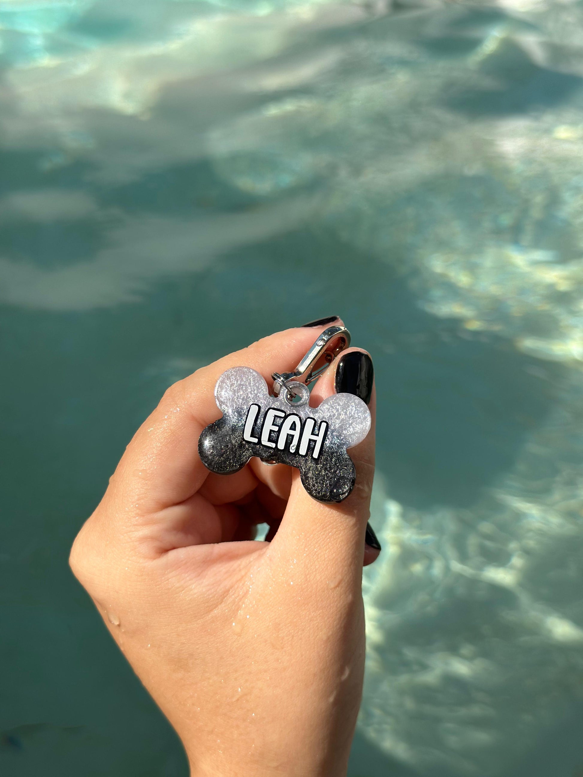 Placa negra y blanca con nombre Leah, resistente al agua. Ideal para aventuras con tu mascota.