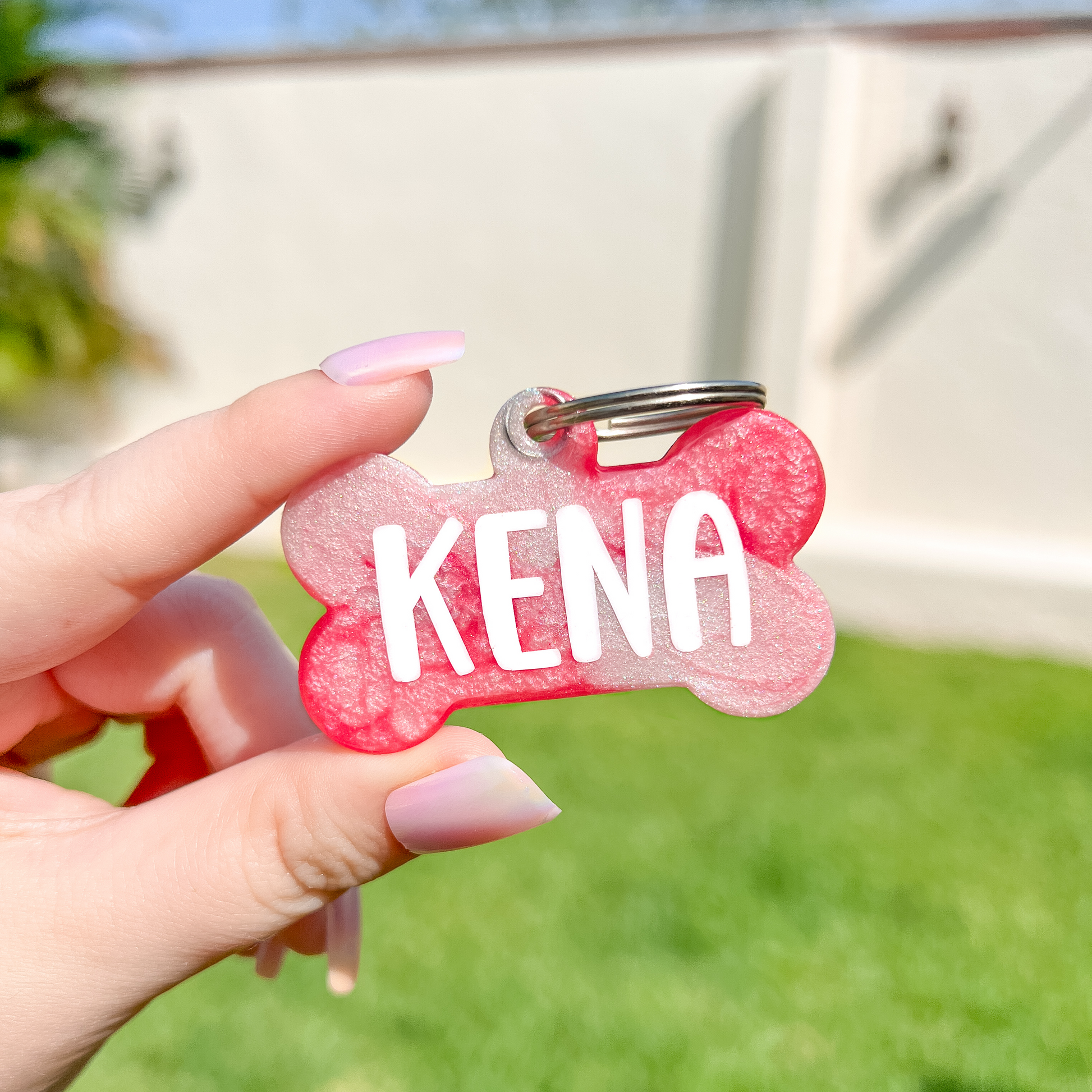 Placa personalizada para perro en forma de hueso color rosa con nombre Kena. Diseño vibrante y resistente de Munmun.