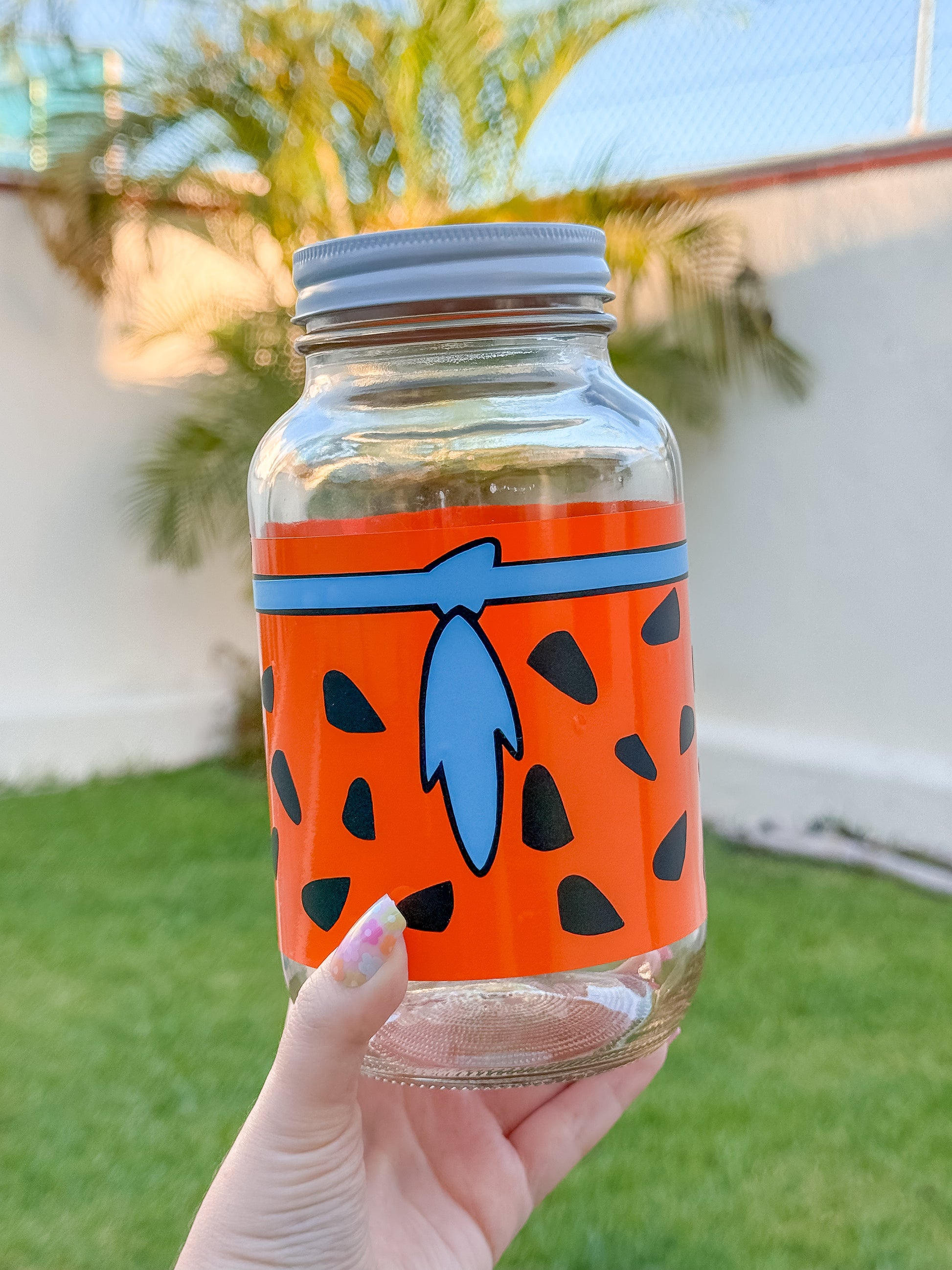 Frasco de vidrio decorado con vinil inspirado en los picapiedras