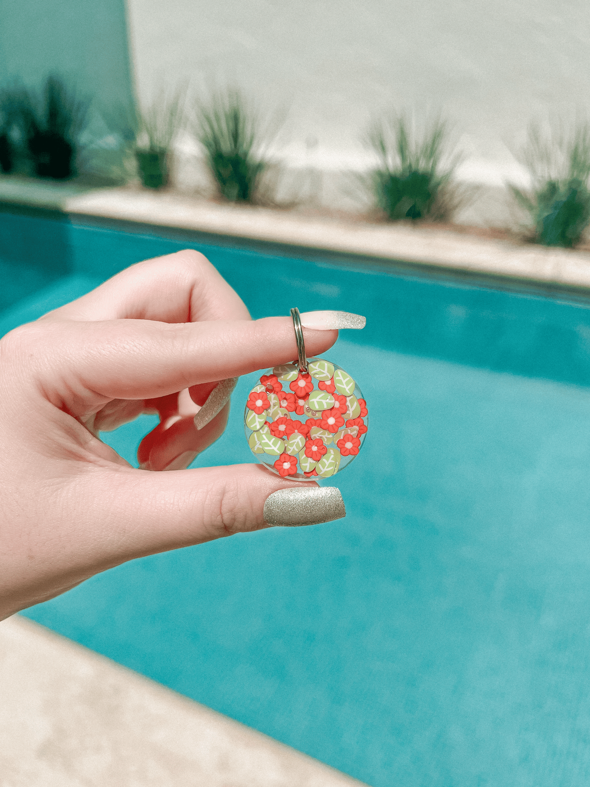 Placa redonda con fondo blanco y flores coral. Accesorio vibrante y femenino.