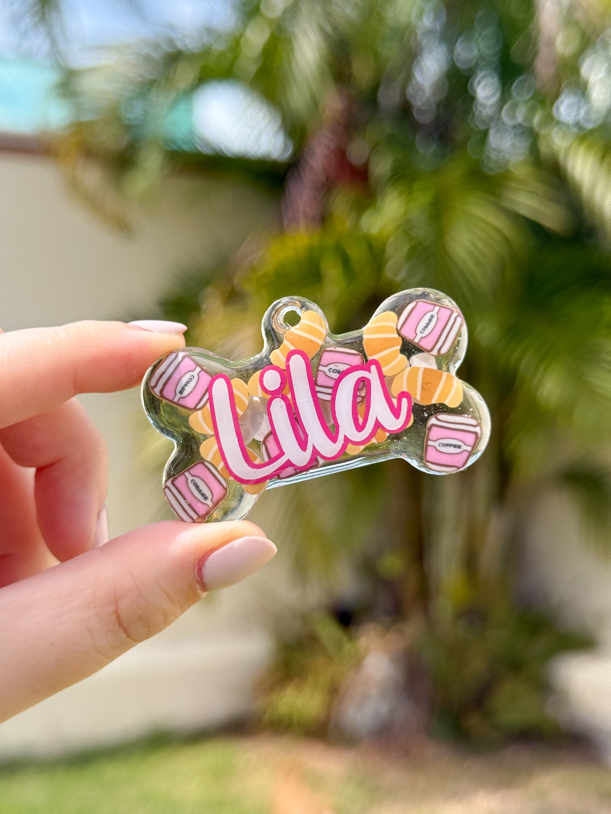 Placa en forma de hueso con nombre Lila y diseño de Croissant. Accesorio creativo y colorido.