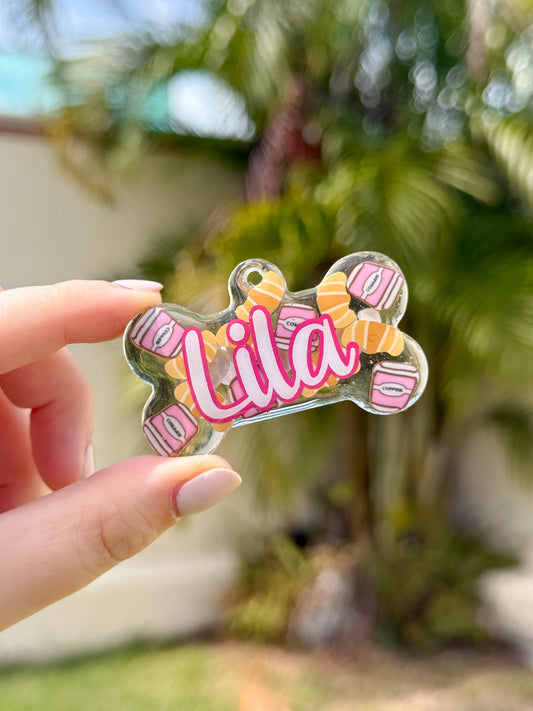 Placa en forma de hueso con nombre Lila y diseño de Croissant. Accesorio creativo y colorido.