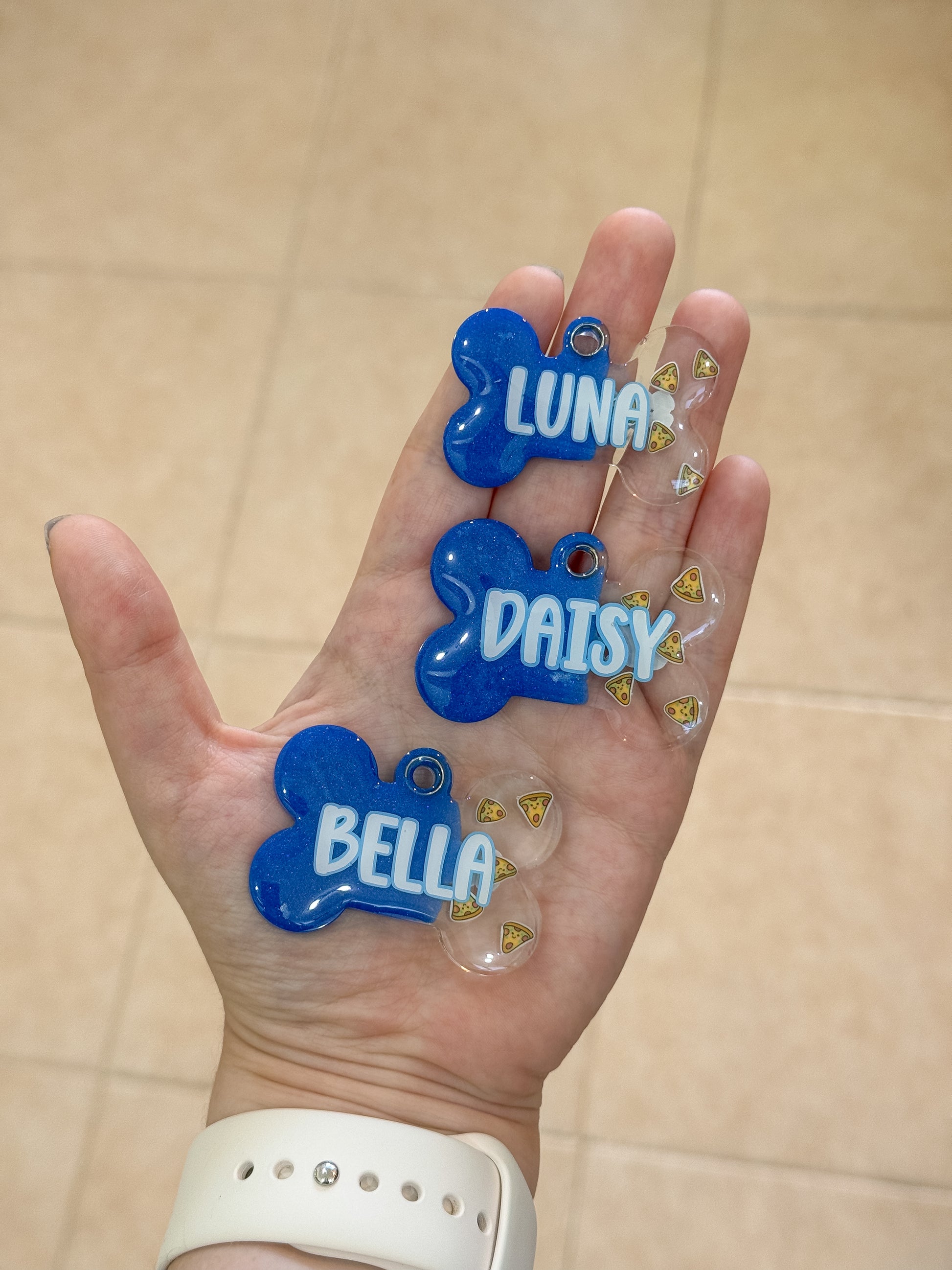 Set de tres placas azules con glitter personalizadas con los nombres Luna, Daisy y Bella. Estilo vibrante para mascotas