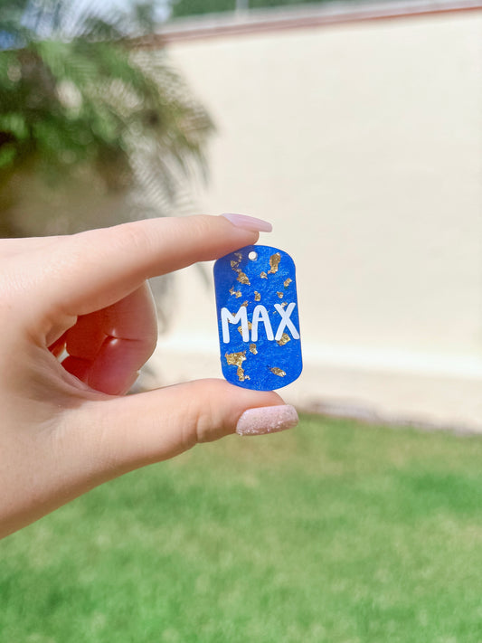 Placa rectangular azul con nombre MAX y detalles en dorado. Diseño sobrio y seguro, ideal para perros medianos y pequeños. Hecha a mano en resina.