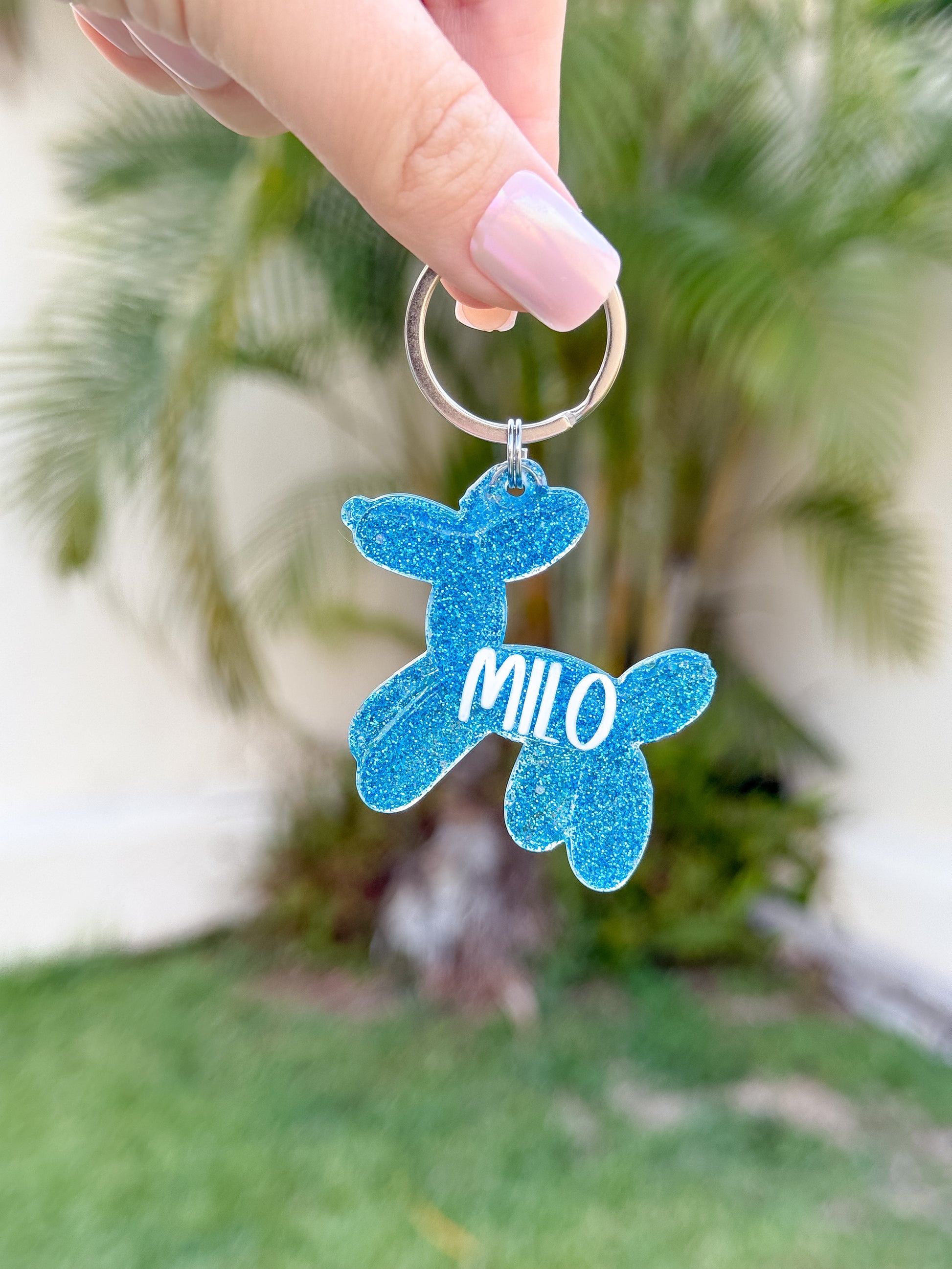Placa azul brillante con forma de perro y nombre Milo. Diseño divertido y personalizado.
