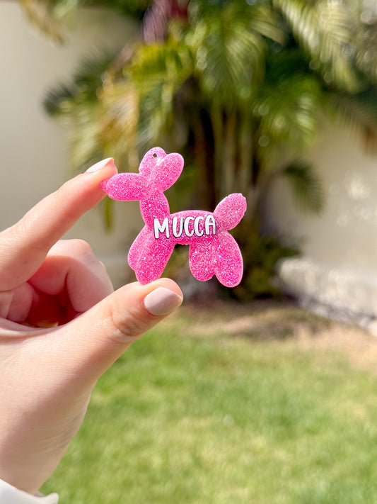 Placa rosa brillante con forma de perrito globo y nombre Mucca. Accesorio con glitter para mascotas.
