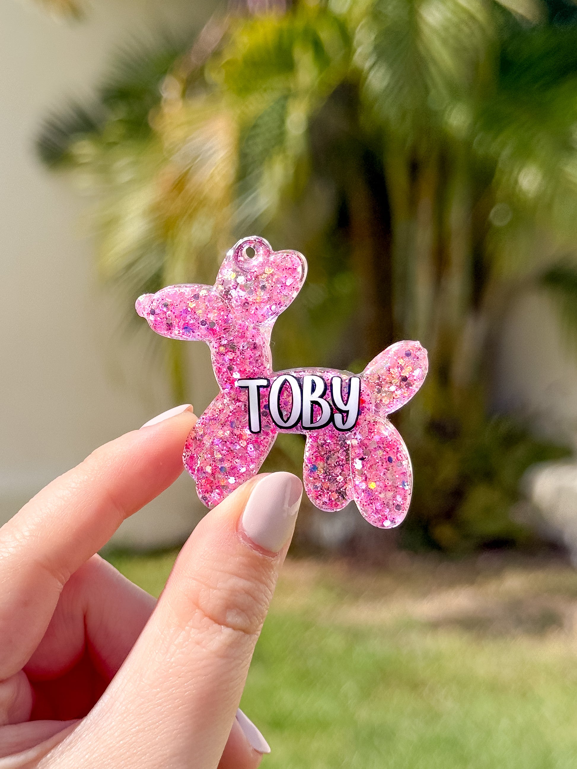 Placa rosa con glitter en forma de perrito globo con nombre Toby. Diseño alegre para mascotas.