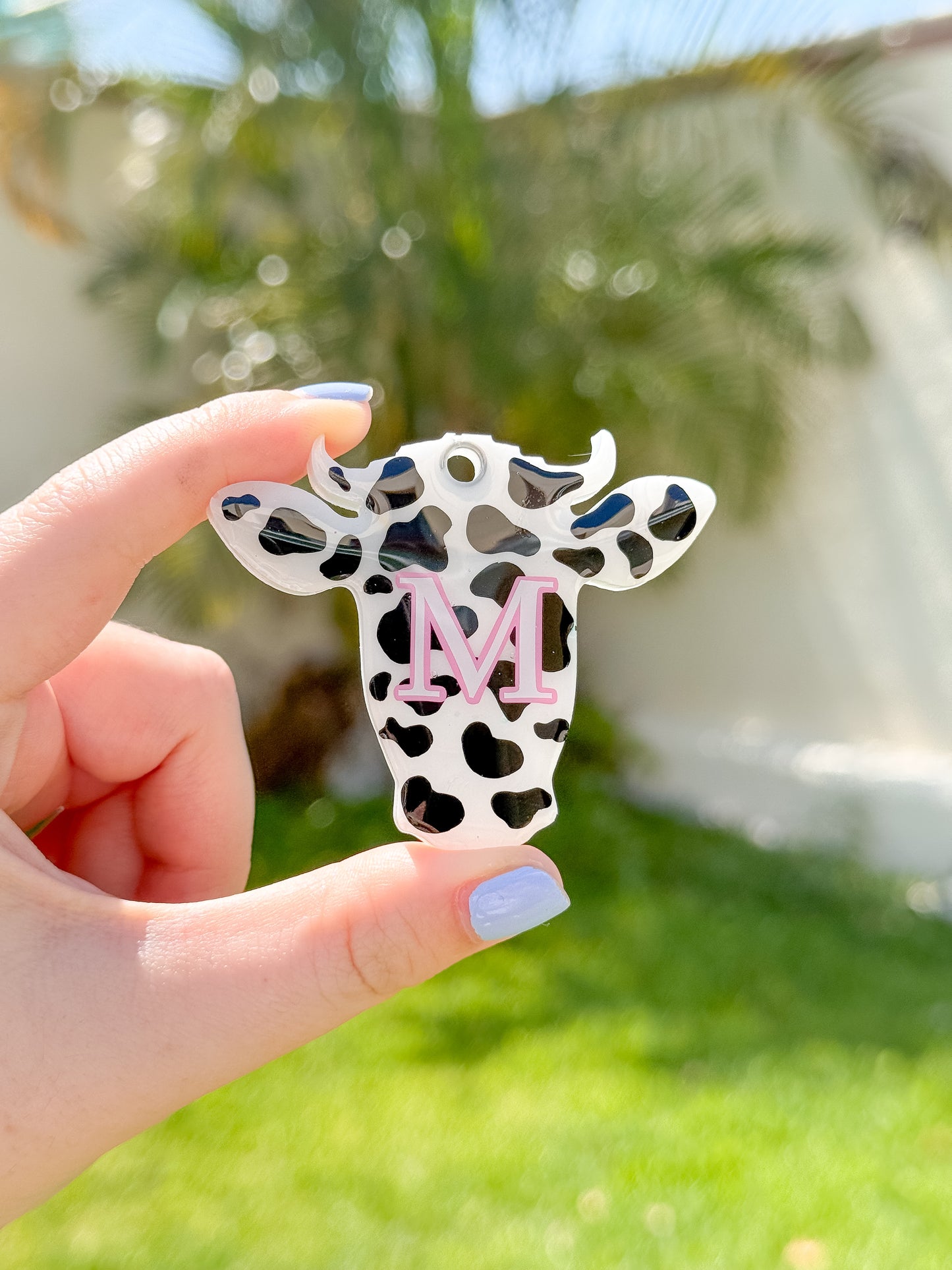 Placa con forma de vaquita en patrón blanco con negro, original y perfecta para perros únicos.