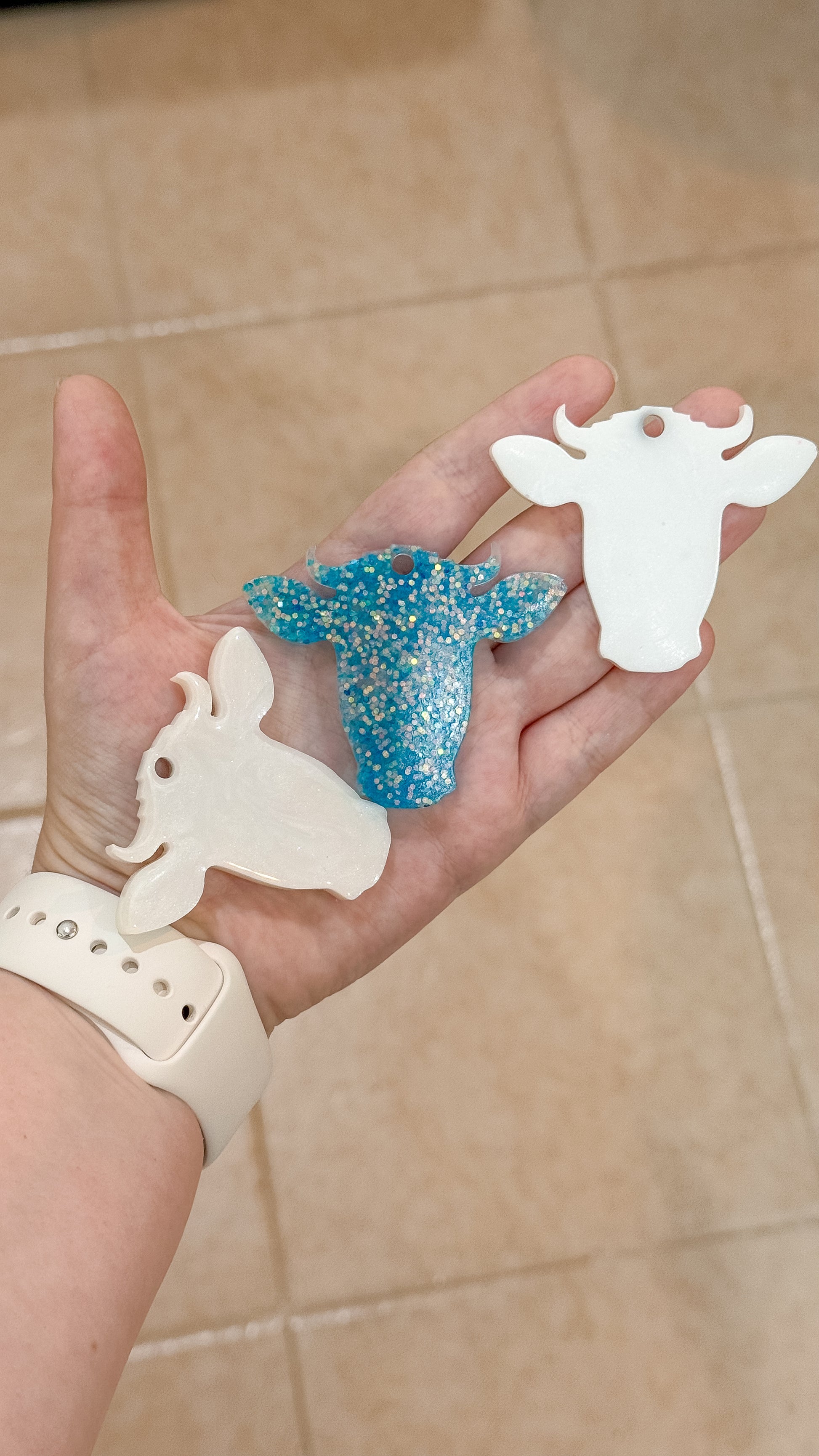 Placas personalizadas en forma de vaquita blanca y con glitter azul. Parte de la colección Munimals, únicas y adorables.