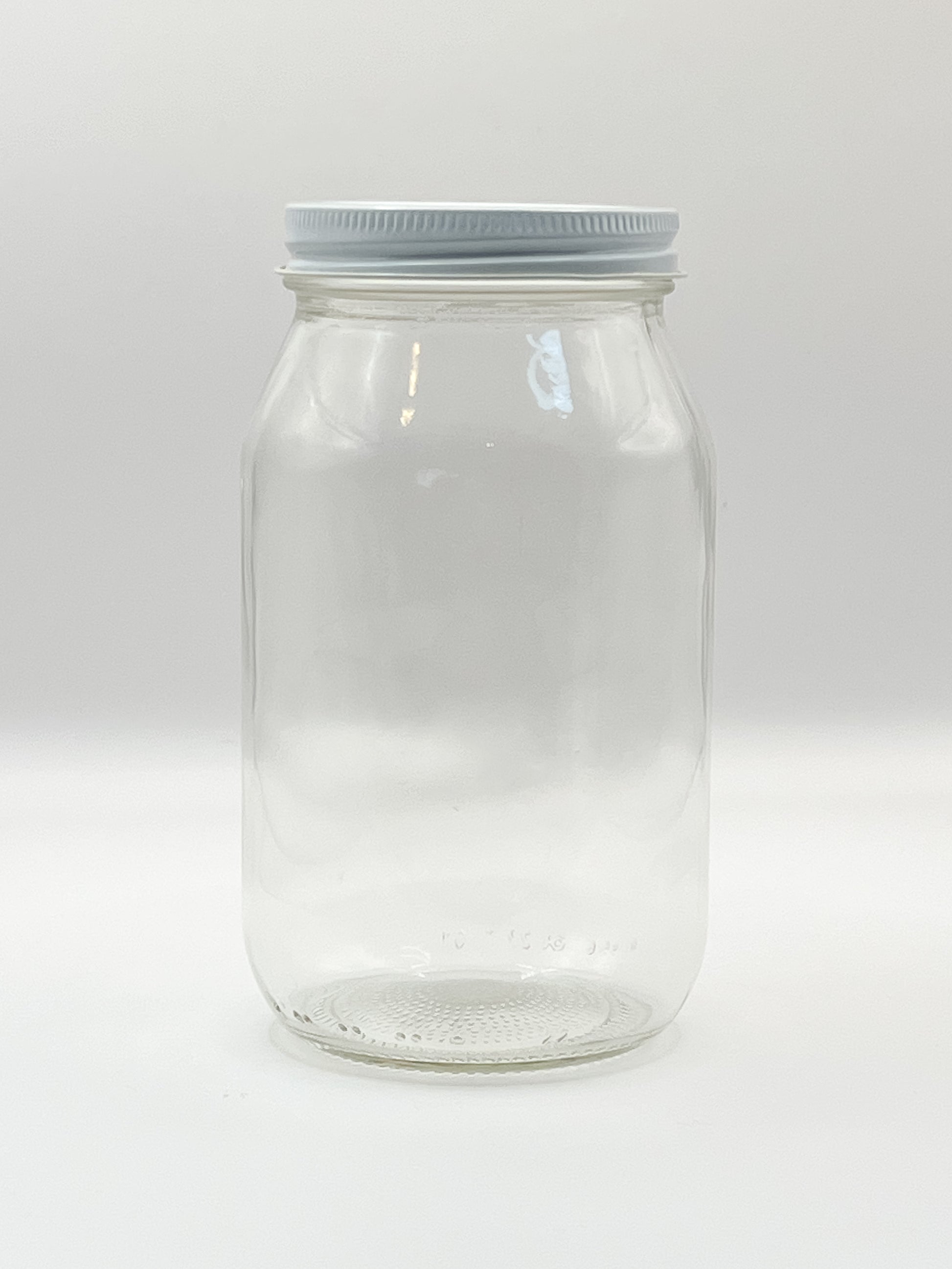 Frasco vacío con tapa plateada. Base ideal para personalización o almacenamiento.