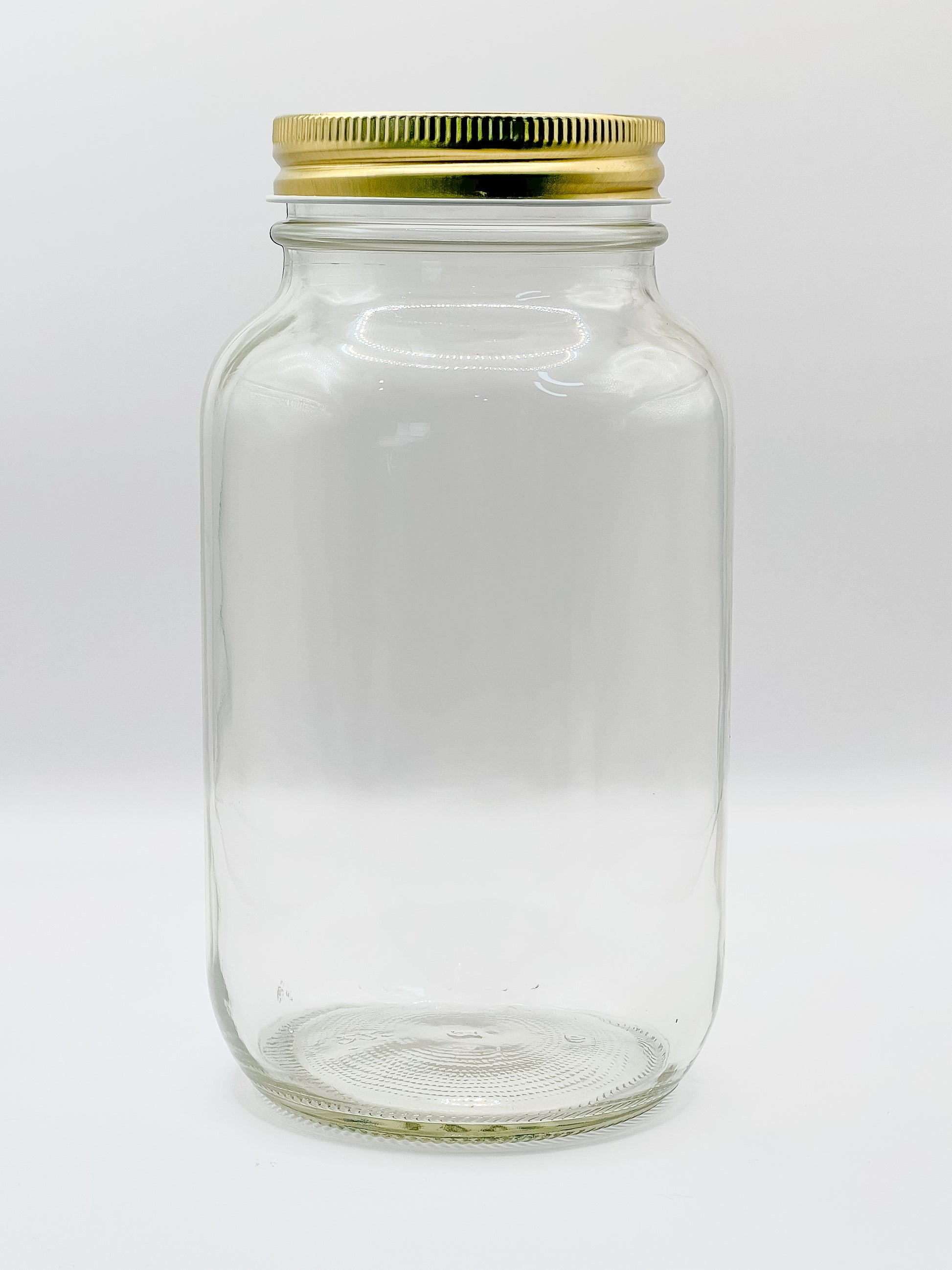 Frasco grande de vidrio con tapa dorada. Diseño básico listo para decorar o rellenar.