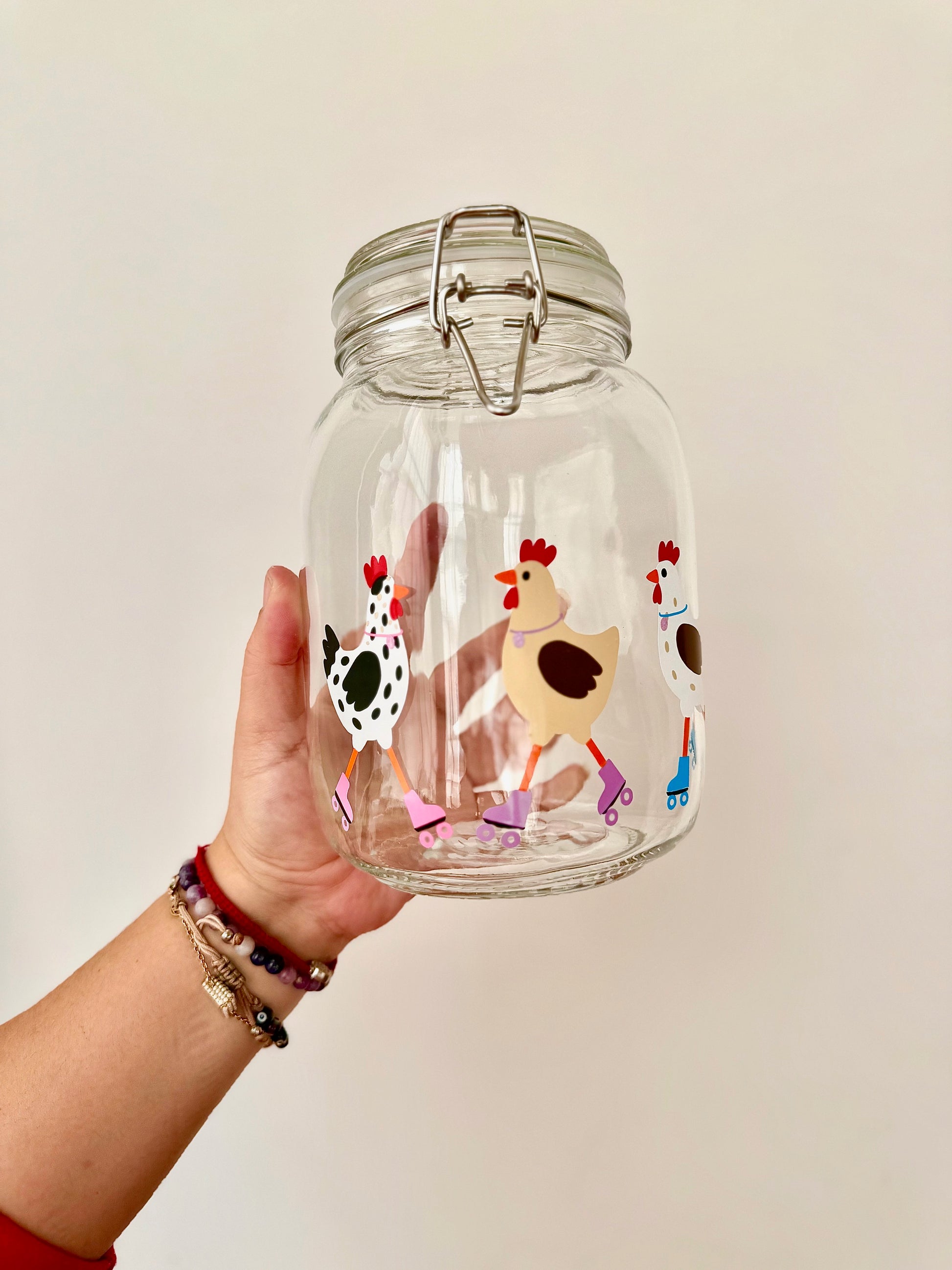 Frasco decorado con gallinitas patinando. Diseño divertido para guardar premios o croquetas.