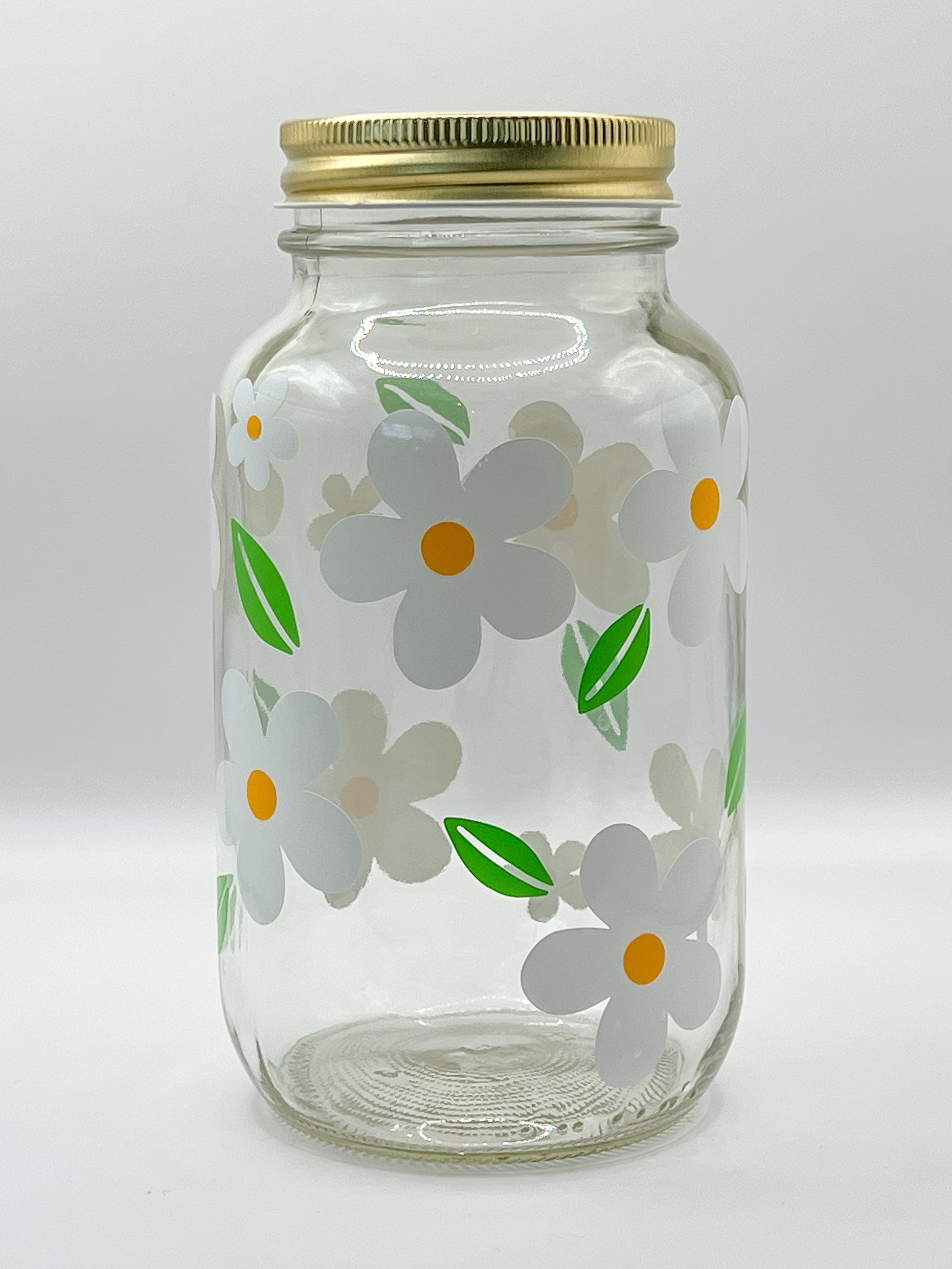 Frasco decorado con margaritas y tapa dorada. Ideal para almacenar croquetas o snacks para perro.