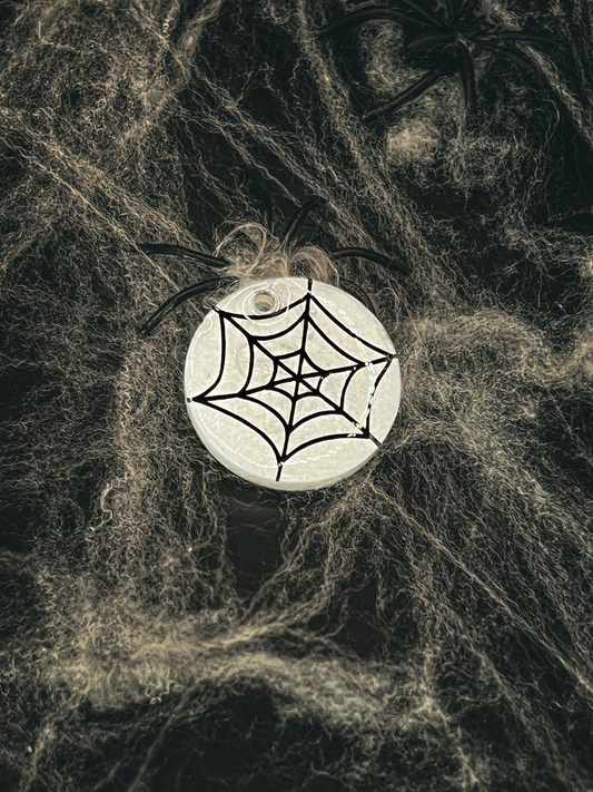Placa circular con diseño de telaraña negra. Decoración temática de temporada.