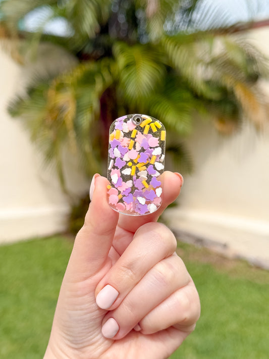 Placa rectangular con fondo rosa y confeti de colores y mariposas. Diseño festivo y alegre para mascotas.