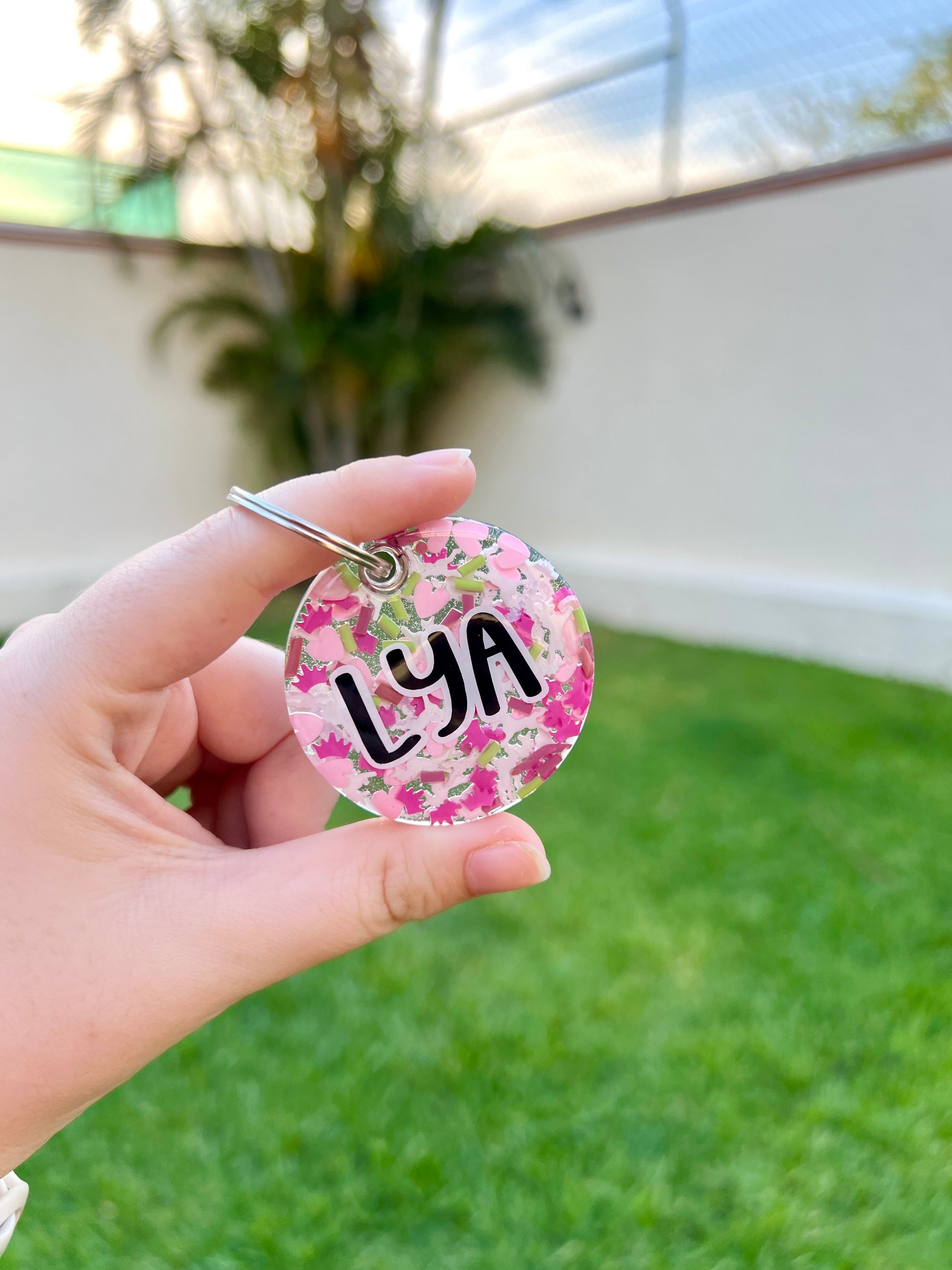 Placa con corazones y nombre Lya en fondo rosa. Diseño personalizado y festivo.