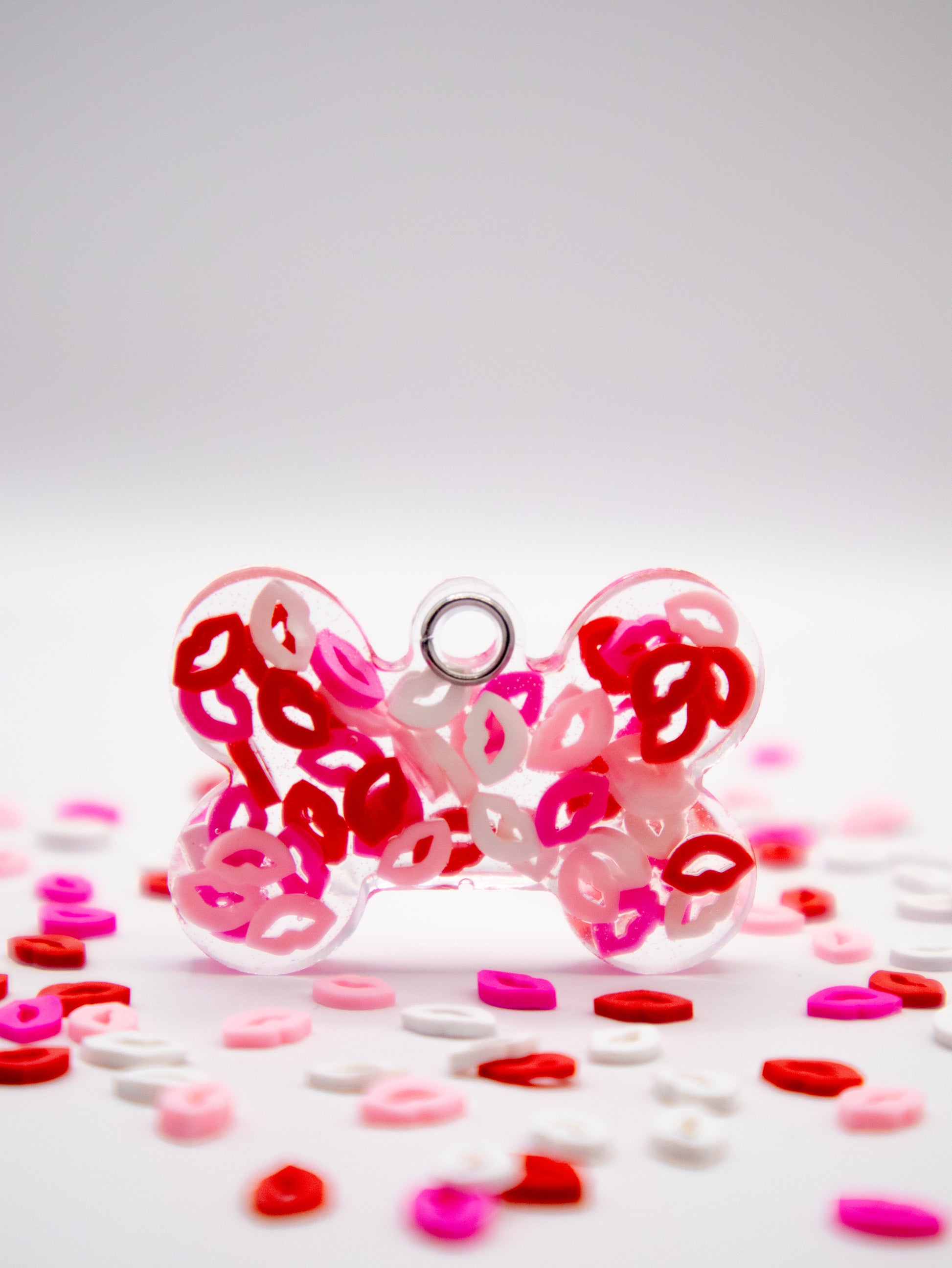 Placa en forma de hueso con confeti rojo y rosa. Estilo amoroso para mascotas.