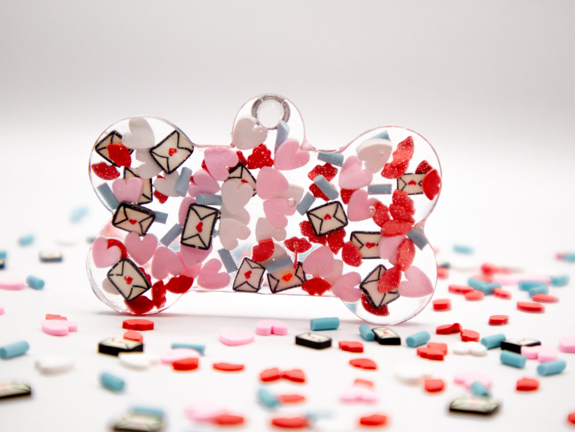 Placa en forma de hueso con confeti rojo y rosa. Estilo amoroso para mascotas.