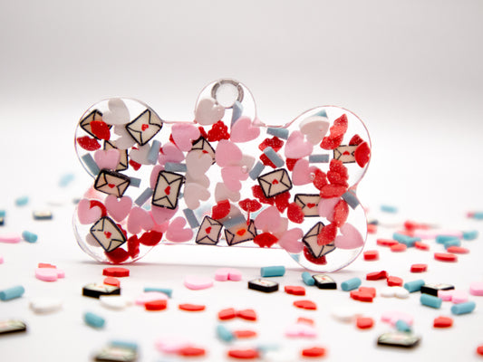 Placa en forma de hueso con confeti rojo y rosa. Estilo amoroso para mascotas.