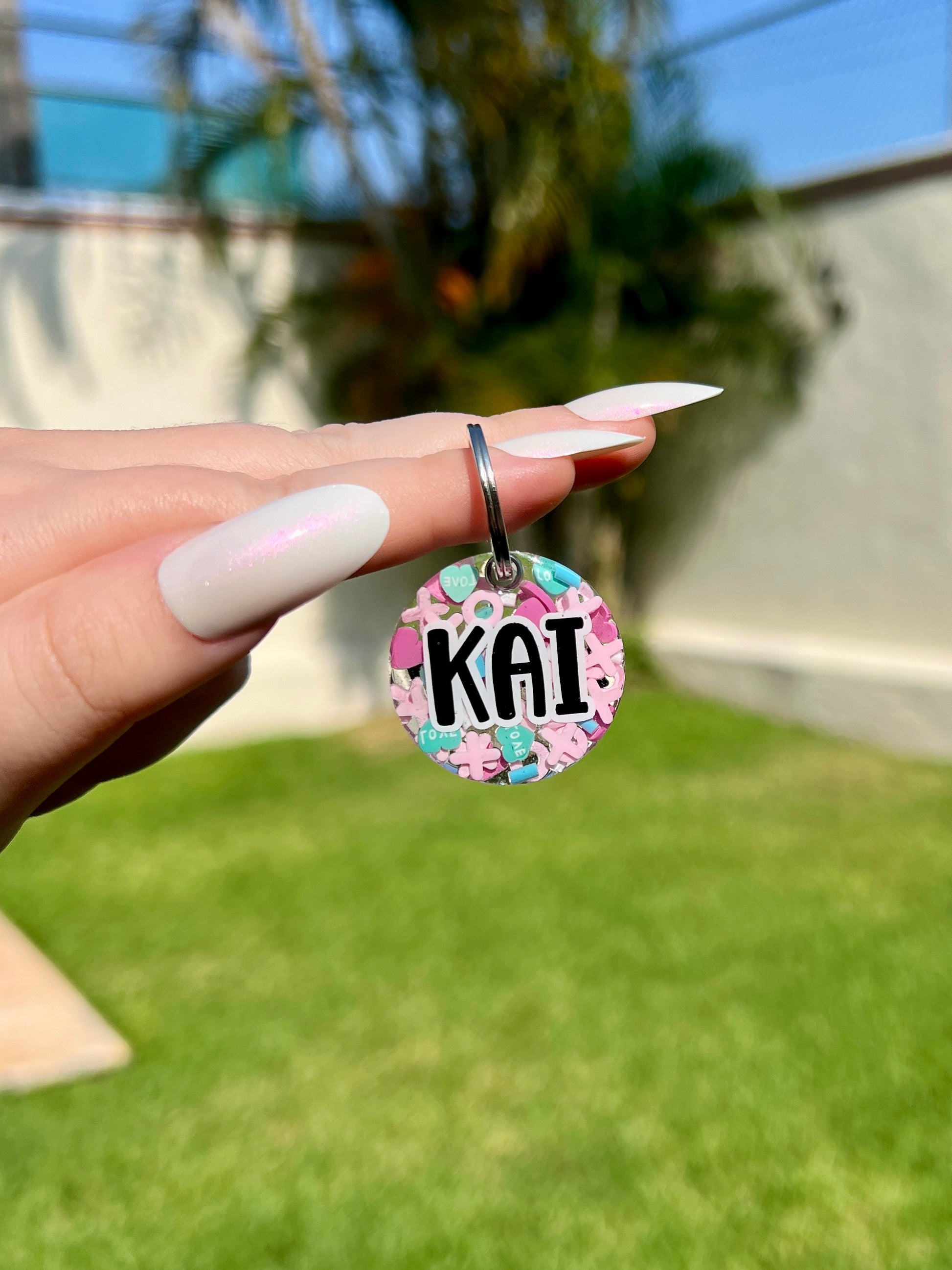 Placa redonda con nombre Kai y fondo colorido. Accesorio divertido y moderno.