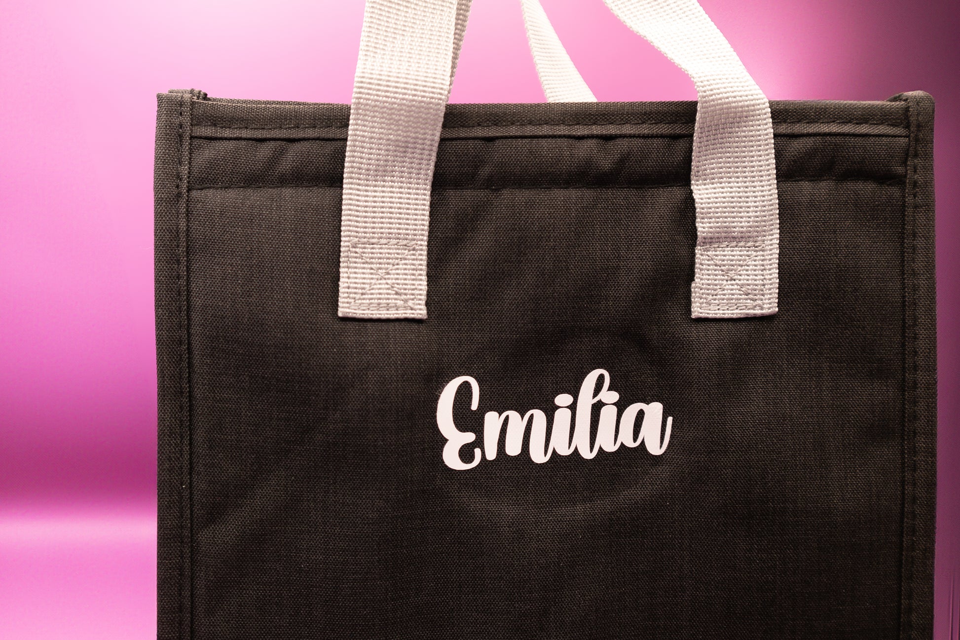 lonchera negra personalizada con nombre Emilia en letras blancas. Ideal para uso diario o regalos.
