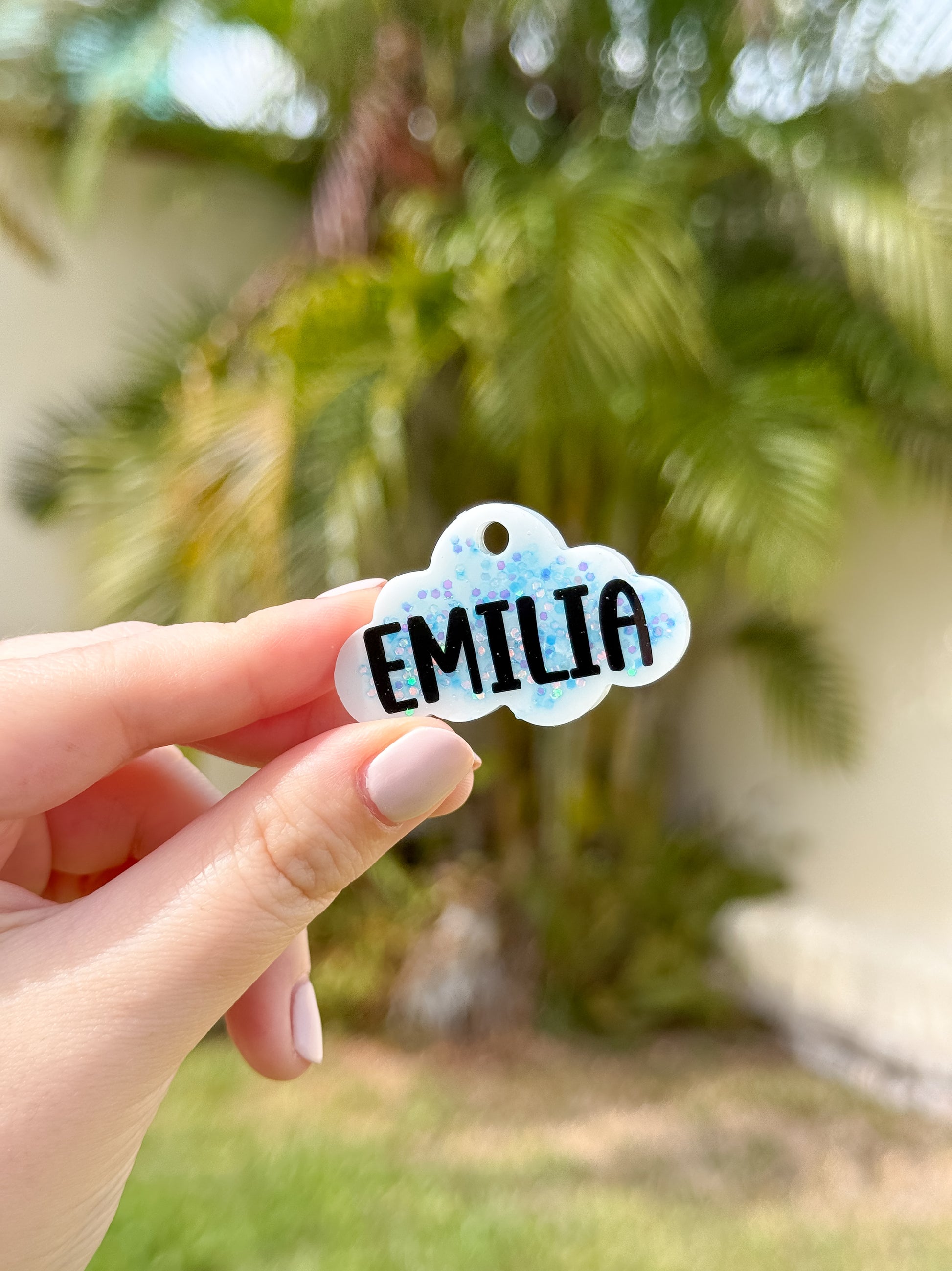 Placa blanca con glitter azul y nombre Emilia. Diseño único para perros con estilo moderno.