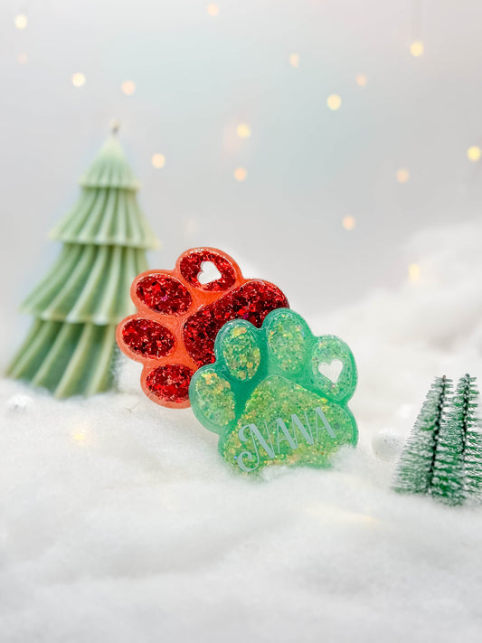 Placas en forma de huella con glitter rojo y verde. Estilo navideño para mascotas.