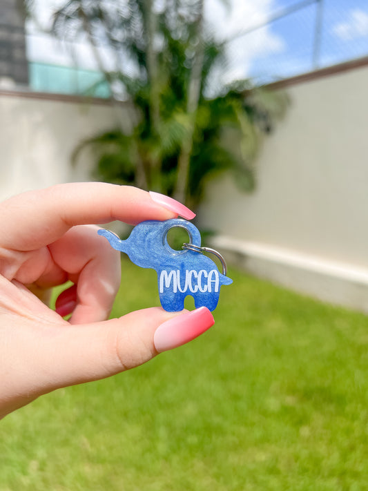 Placa azul con forma de elefante y nombre Mucca. Diseño llamativo y juguetón.