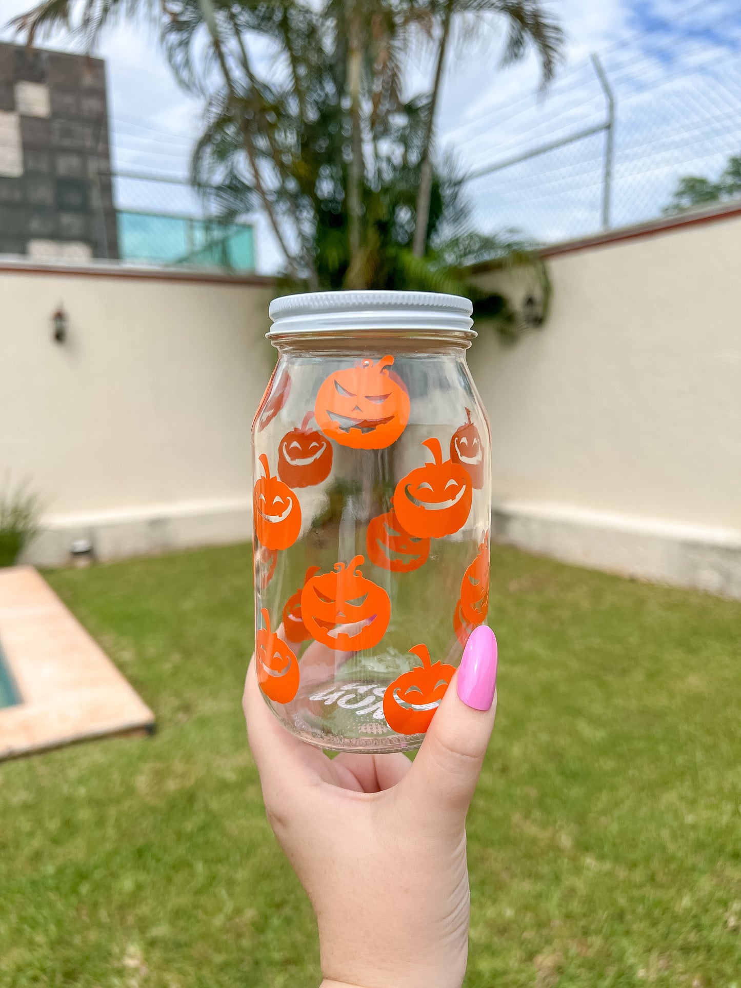 Frasco de vidrio decorado con calabazas naranjas. Ideal para guardar premios de tu perrito durante la temporada de Halloween.
