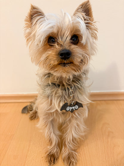 yorkie con placa de murciélago y nombre otto. Accesorio decorativo para temporada.