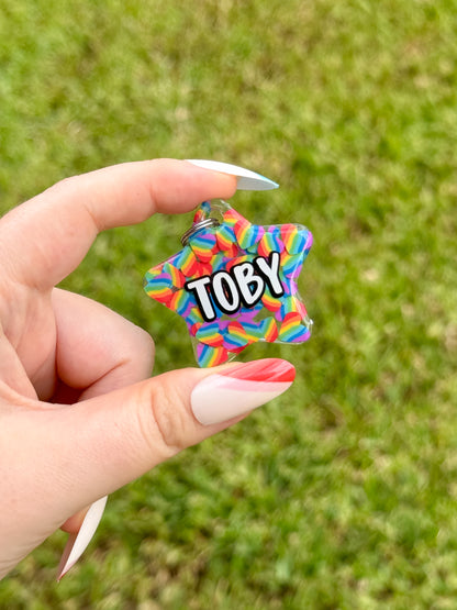 Placa pequeña con nombre “Toby” y chispas de colores, perfecta para perritos con mucha personalidad.